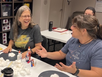 Two teachers working and discussing classroom activities at a table.